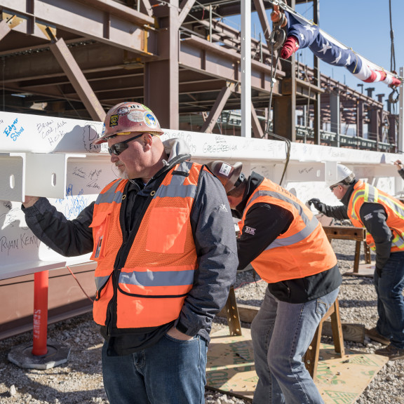 Workers signing beam at Concourse A East Topping Out ceremony October 13 2021
