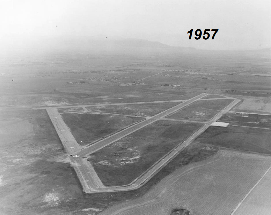 Aerial photo showing runway in a rural setting.